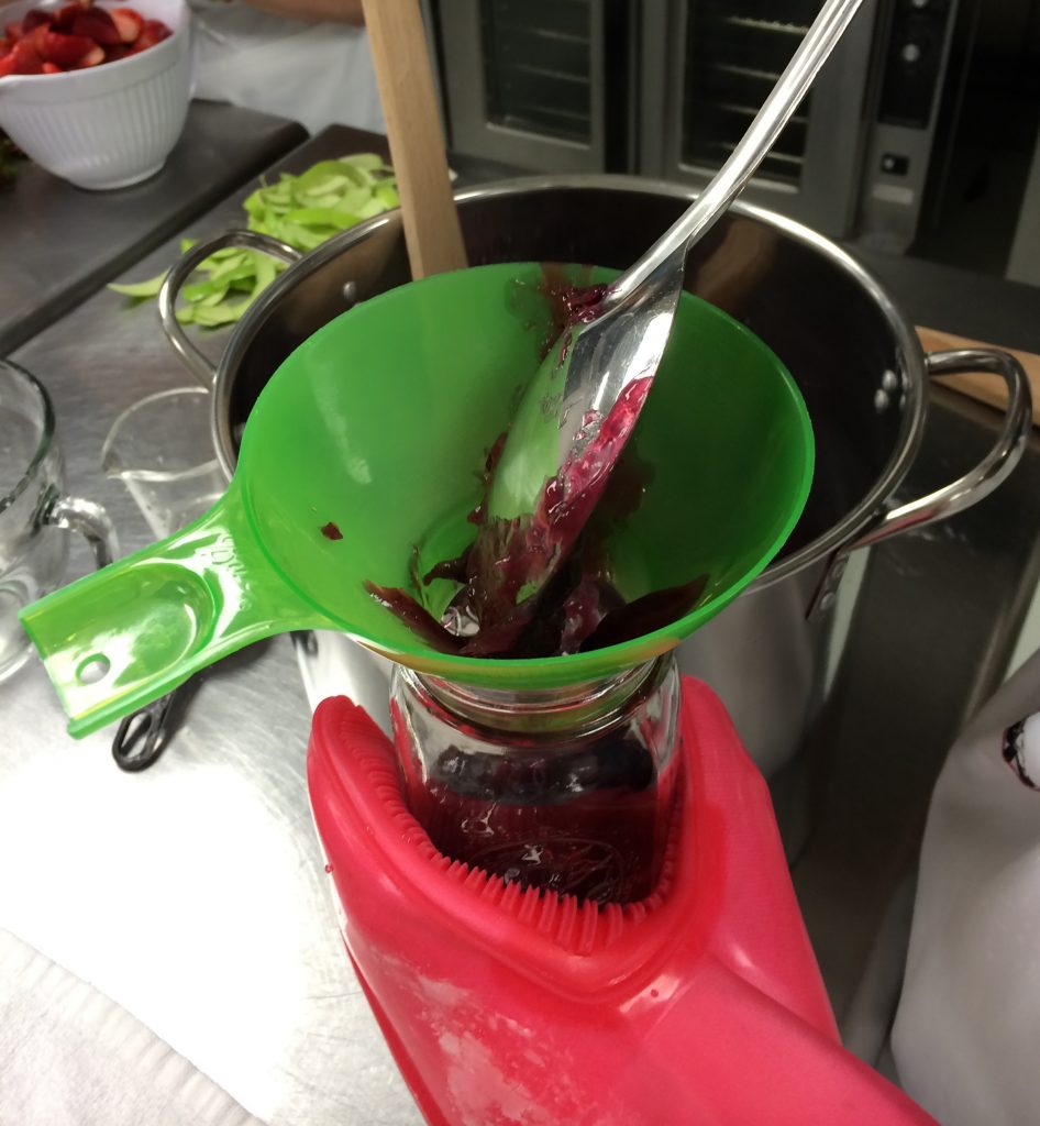 ladle blueberry pie filling into jars